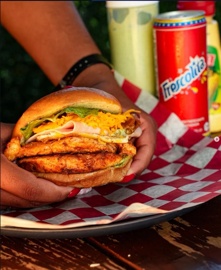 Burger de pollo en mano con Frescolita